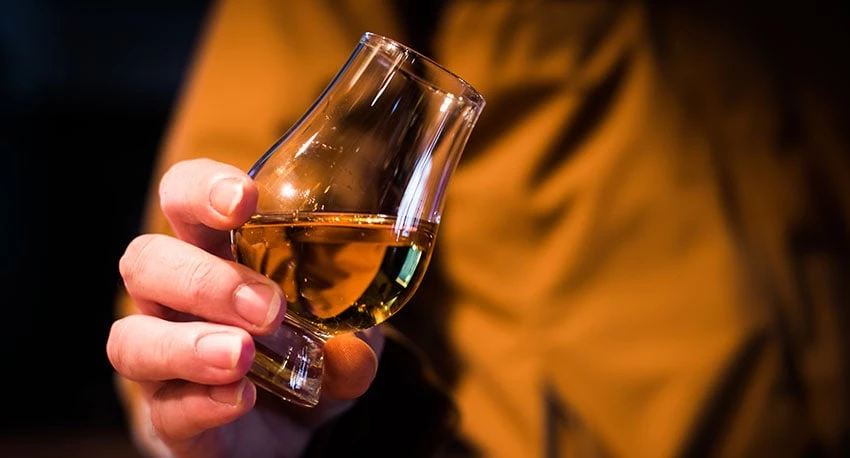 Person holding a glass of rum