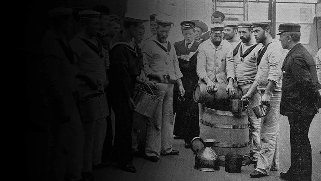 People standing around a rum barrel
